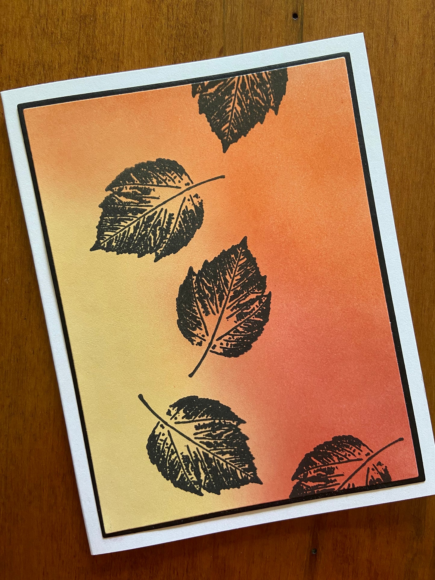 Autumnal oranges, yellows, and reds are ink blended together. 4 Black silhouette poplar leaves are stamped here and there.