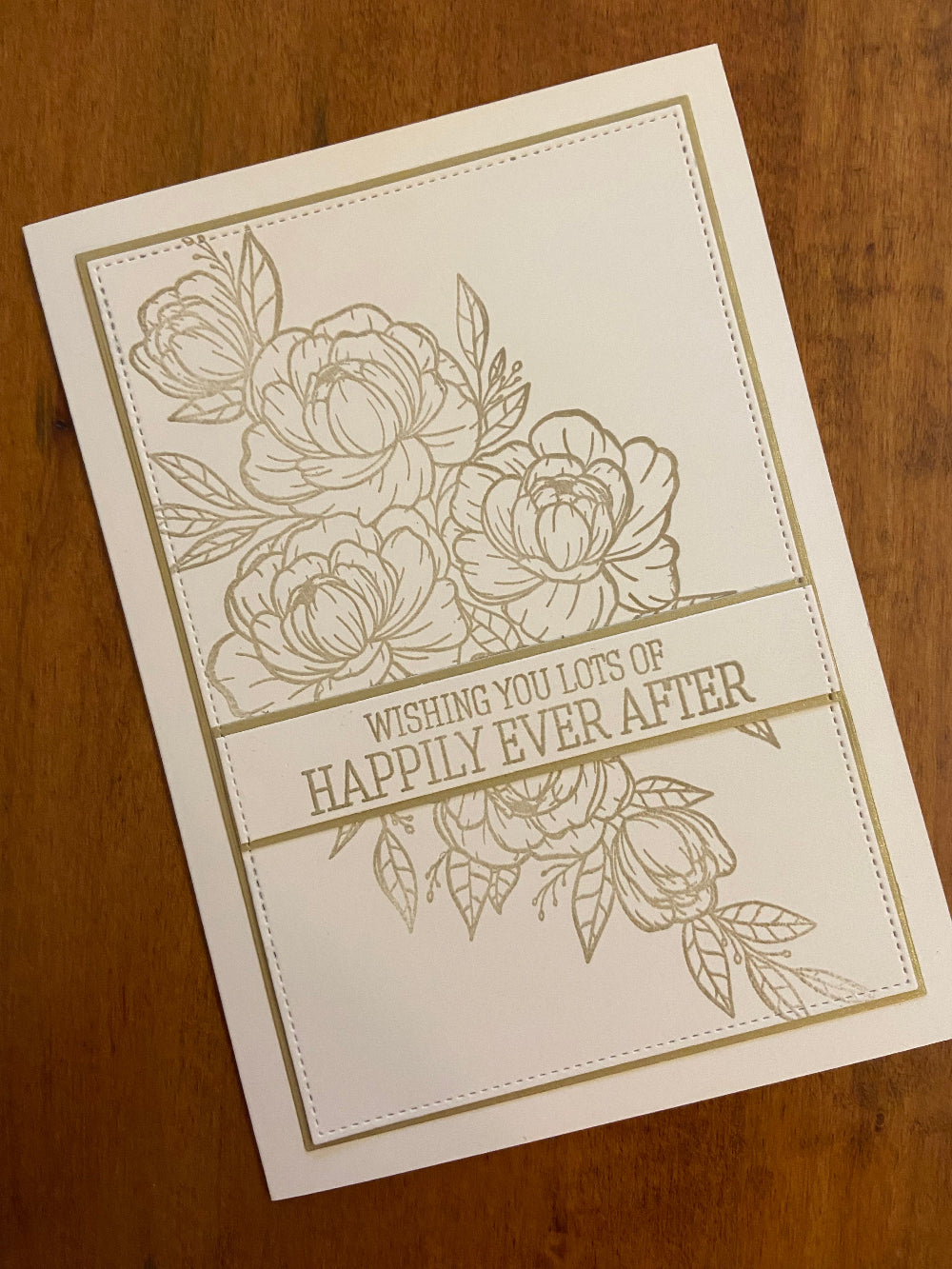Gold and ivory handmade wedding card. Gold floral and greenery outline stamp with a gold happily ever after sentiment.