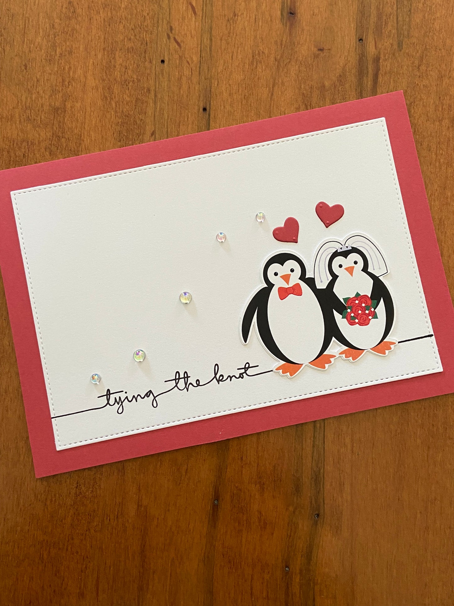 Tying the Knot Wedding Card autumnal orangey-red and white Handmade card; penguin bride & groom with orangey-red hearts above them. A little sparkle is added from some shiny pearls accross the front