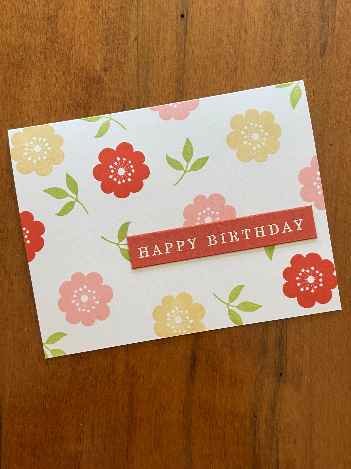 Floral Happy Birthday card; part of a 2 card set; handmade. Pink, yellow and mahogany flowers with little green leaves.