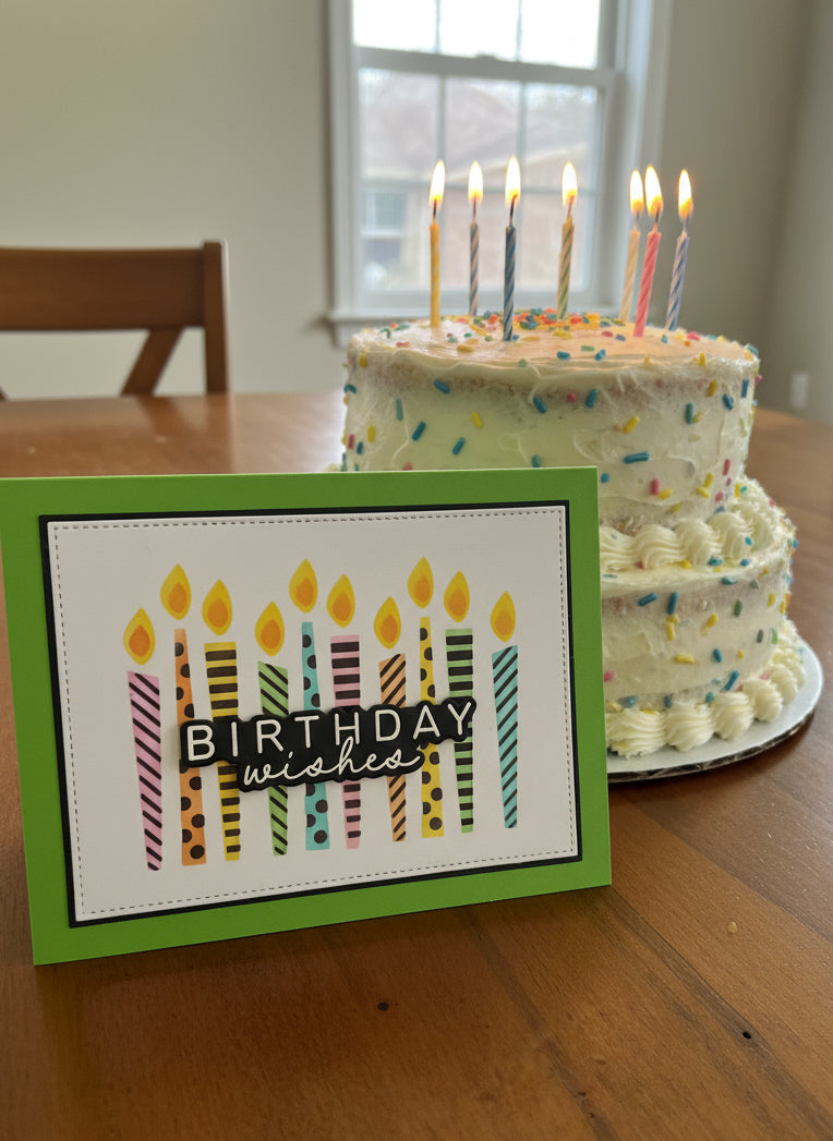 Birthday card with colourful candles beside birthday cake