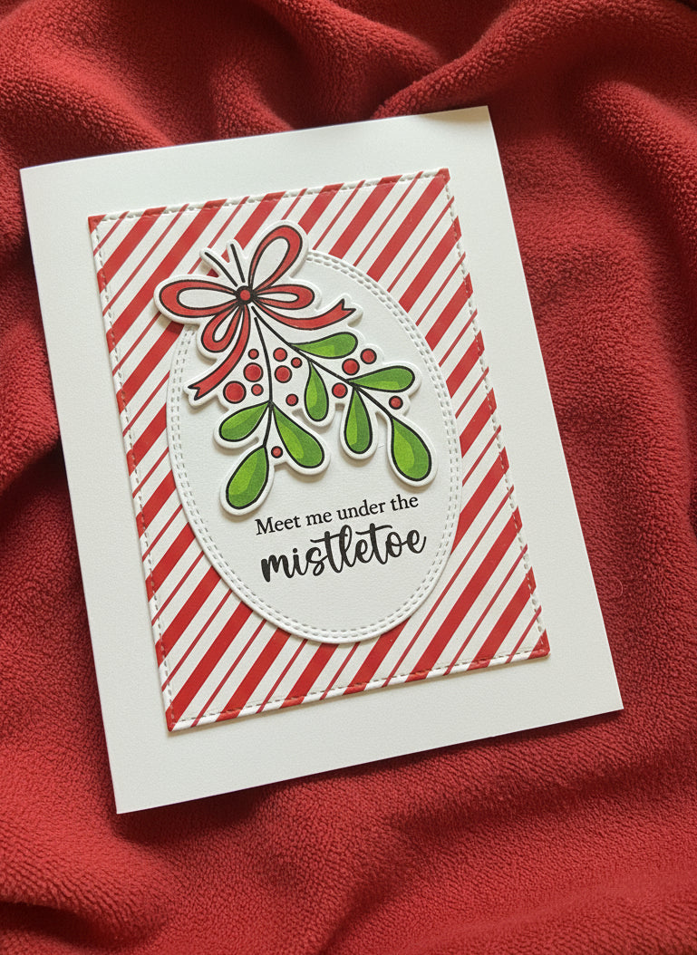 Christmas card with mistletoe design on a red fabric background