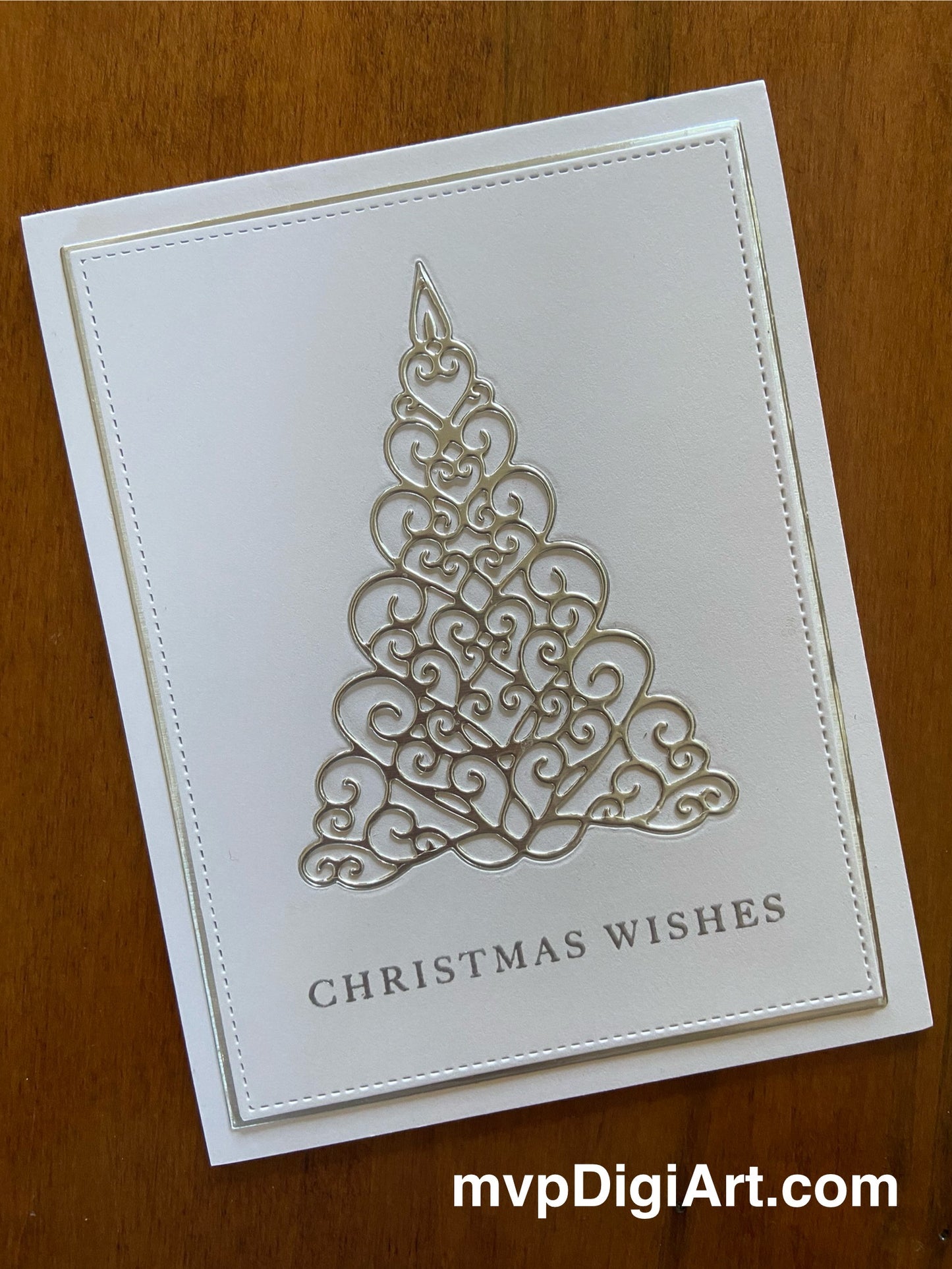 A handmade Christmas card featuring a silver filigree Christmas tree on a white background with a 'Christmas Wishes' embossed text