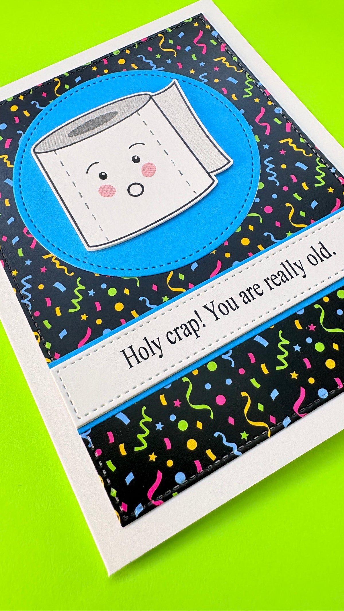 Close-up of black Confetti Background patterned cardstock on a handmade birthday card, showing pink, blue, yellow and lime green dots, stars and streamers with stitched-edge detailing.