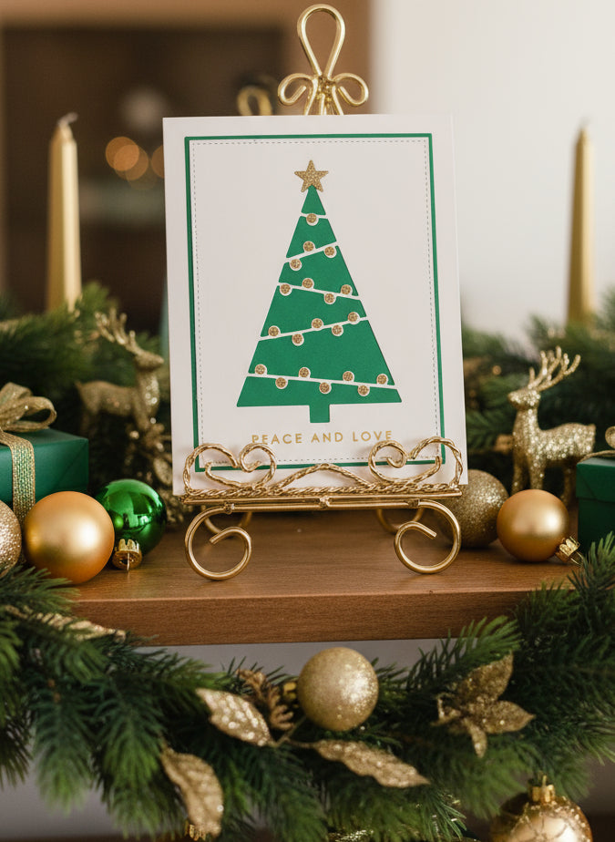 Christmas card with modern green, white, and gold graphic tree design displayed with festive holiday decorations