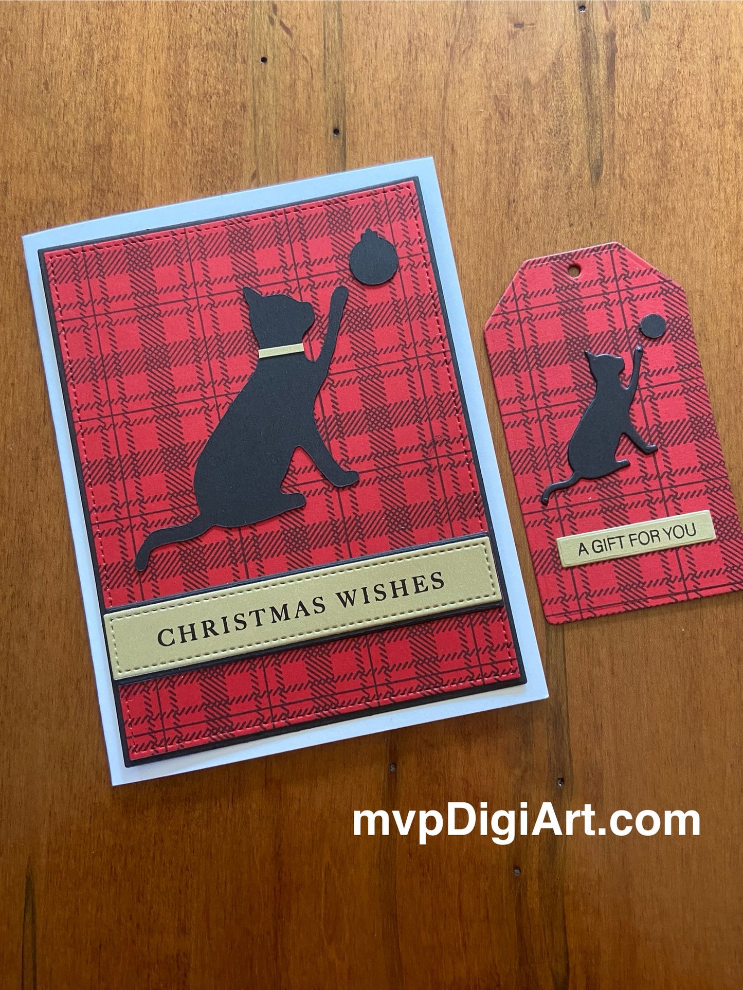 A Christmas card featuring a black cat silhouette playing with a Christmas ball on a red and black plaid background, accompanied by a matching gift tag.