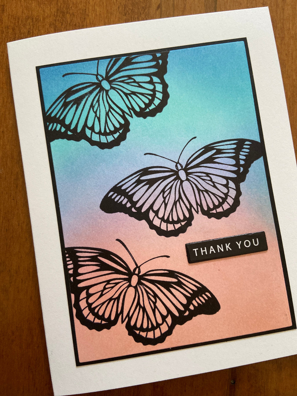 Card with butterfly designs and 'Thank You' text on a gradient background