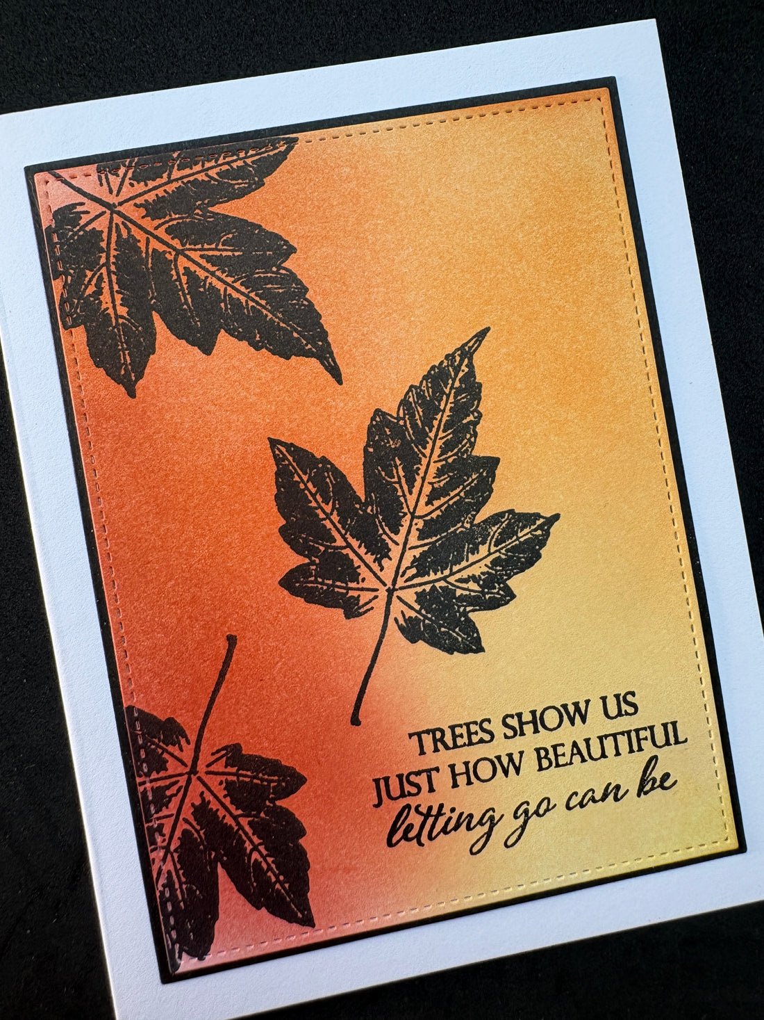 Handmade card featuring a soft ink blended background panel with black silhouette leaves  stamped text: Trees show us just how beautiful letting go can be.