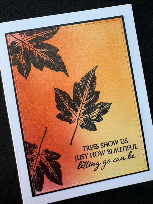 Handmade card featuring a soft ink blended background panel with black silhouette leaves  stamped text: Trees show us just how beautiful letting go can be.