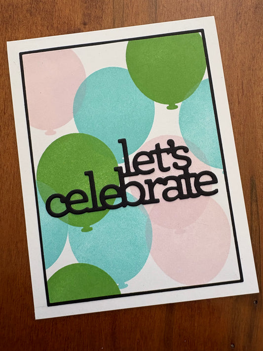 Handmade celebration card featuring ink-blended balloon stencilling in blue, green, and pink with a dimensional "let's celebrate" die cut sentiment