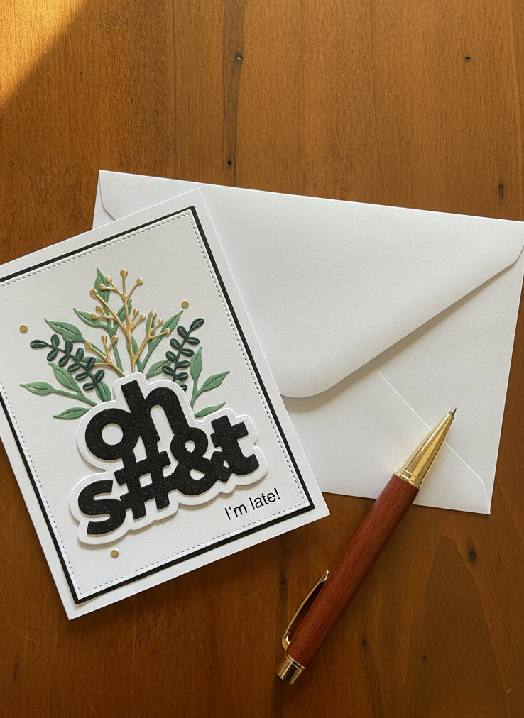 Card with 'oh $#@&! I'm late!' text and envelope on a wooden surface