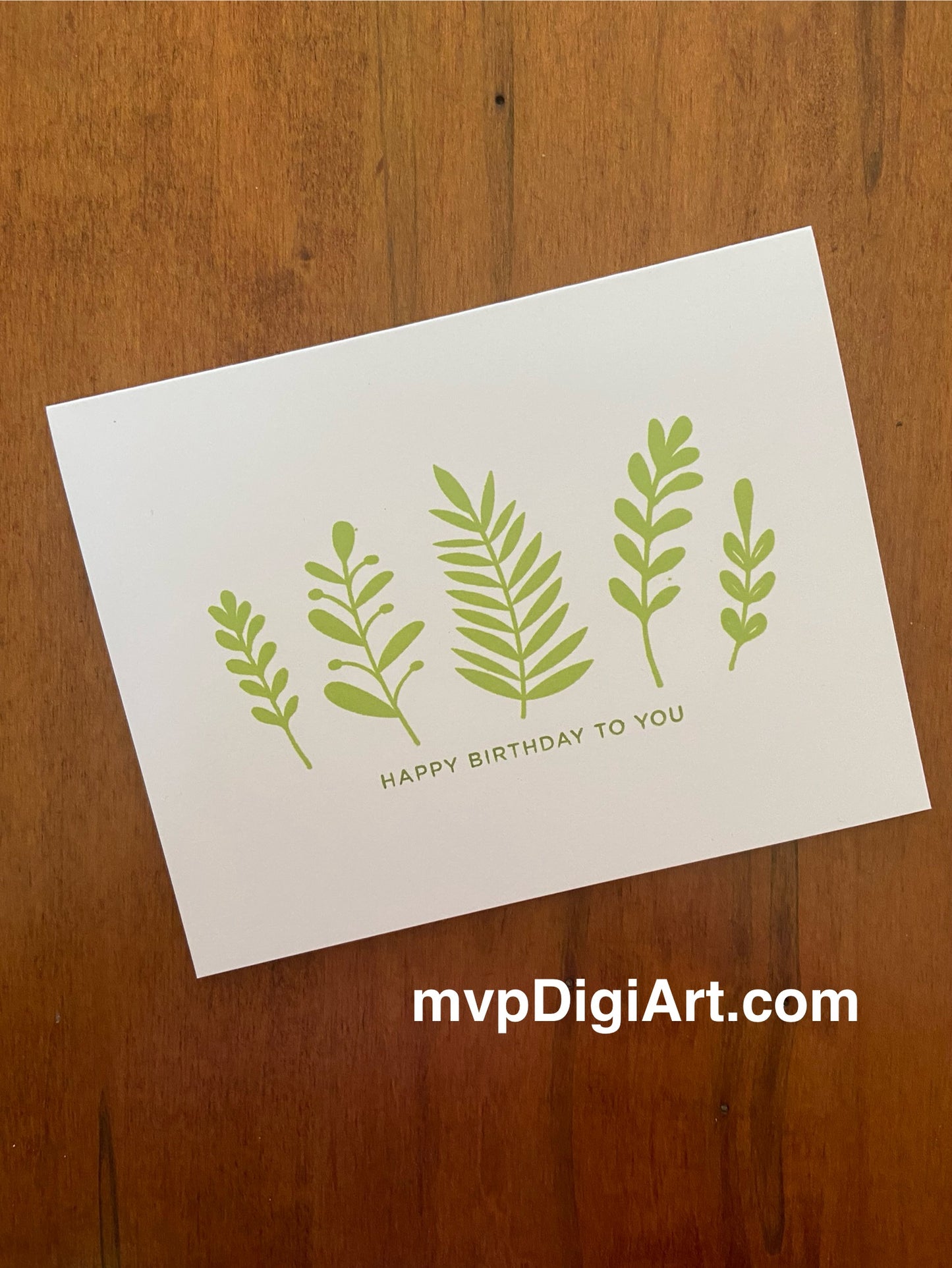 Happy birthday handmade card featuring green botanical foliage.