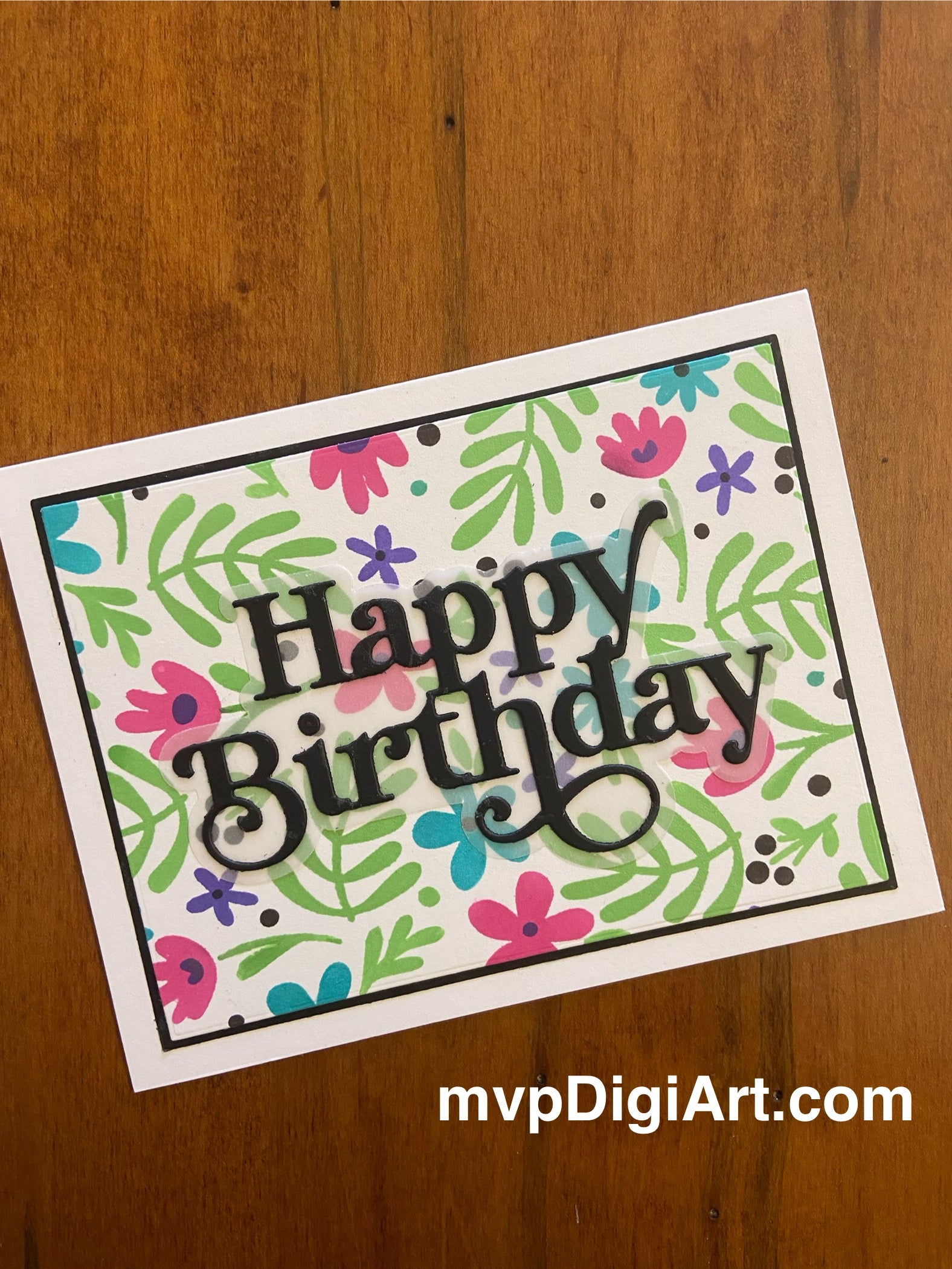 Handmade birthday card featuring metallic stencilled flowers and foliage in pink, blue, purple and green with bold black die-cut Happy Birthday sentiment on black matted panel