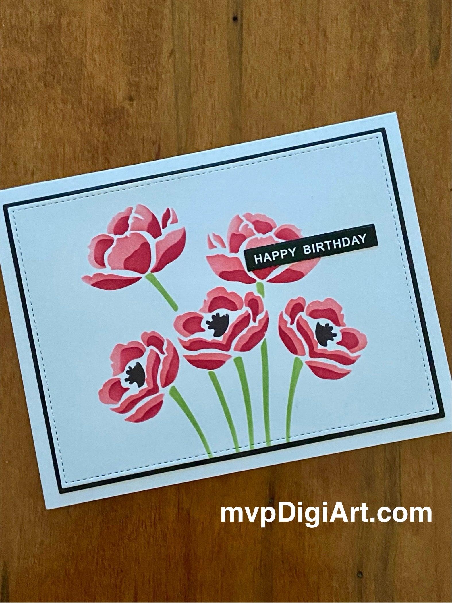 Handmade birthday card with red poppies blowing in the wind, elegant floral design on white background, white happy birthday text on black strip