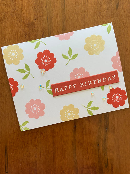 Handmade birthday card with yellow, pink and mahogany floral stamps, greenery and crystal gems