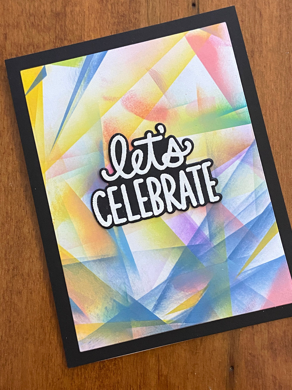 Colourful abstract design with 'Let's Celebrate' text 