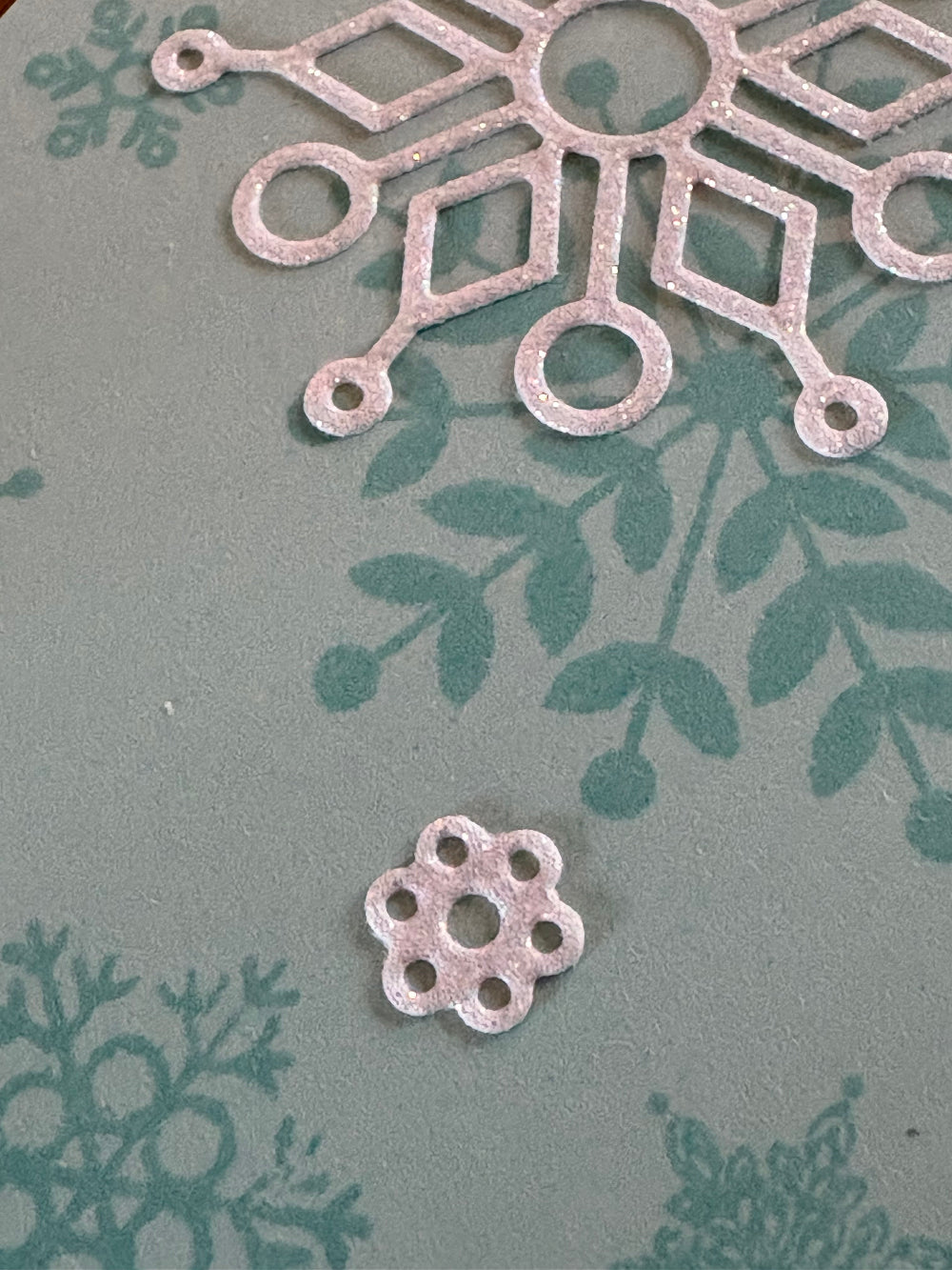 Close-up detail of Christmas card showing blue and white snowflakes design with decorative accents