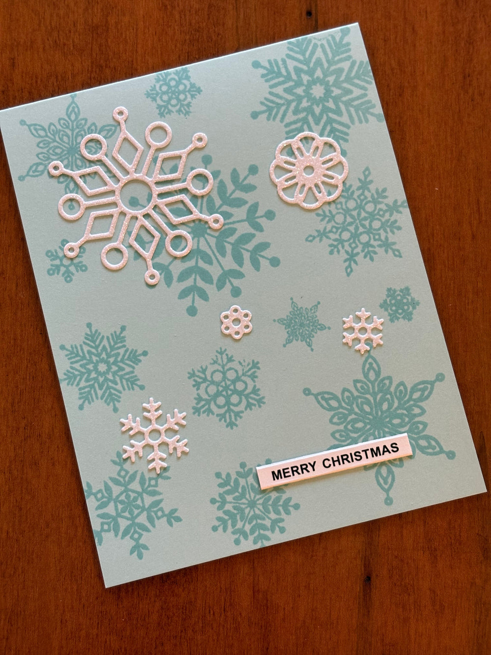 Handmade Christmas card with blue and white snowflakes design on white background