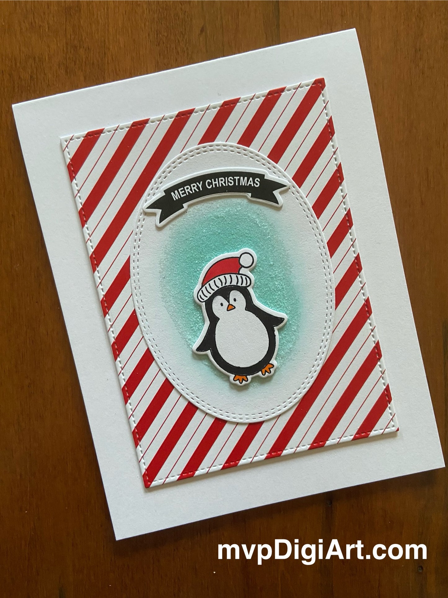 Handmade Christmas card with cute penguin character on candy cane striped background and Merry Christmas banner
