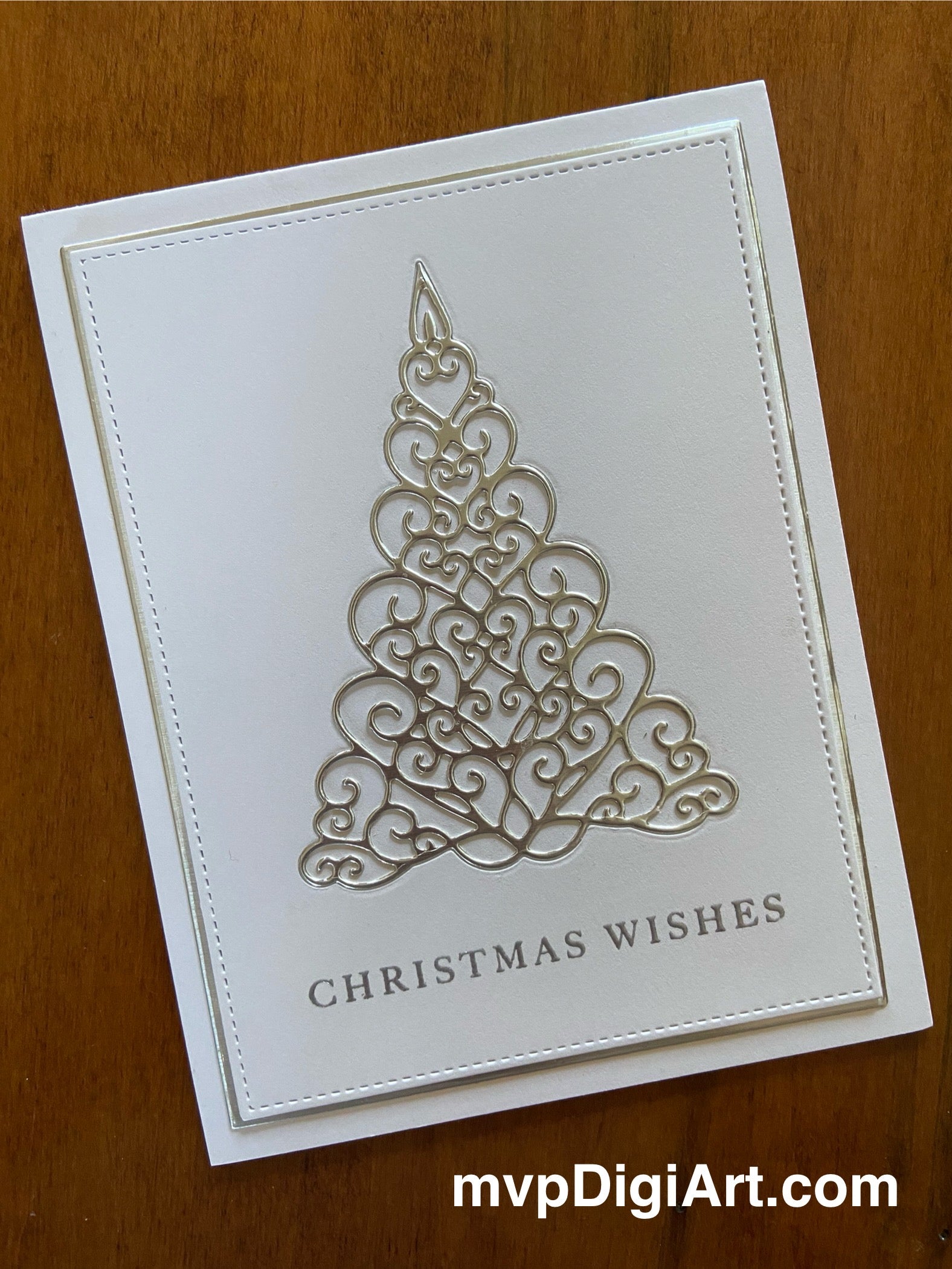 A handmade Christmas card featuring a silver filigree Christmas tree on a white background with a 'Christmas Wishes' embossed text
