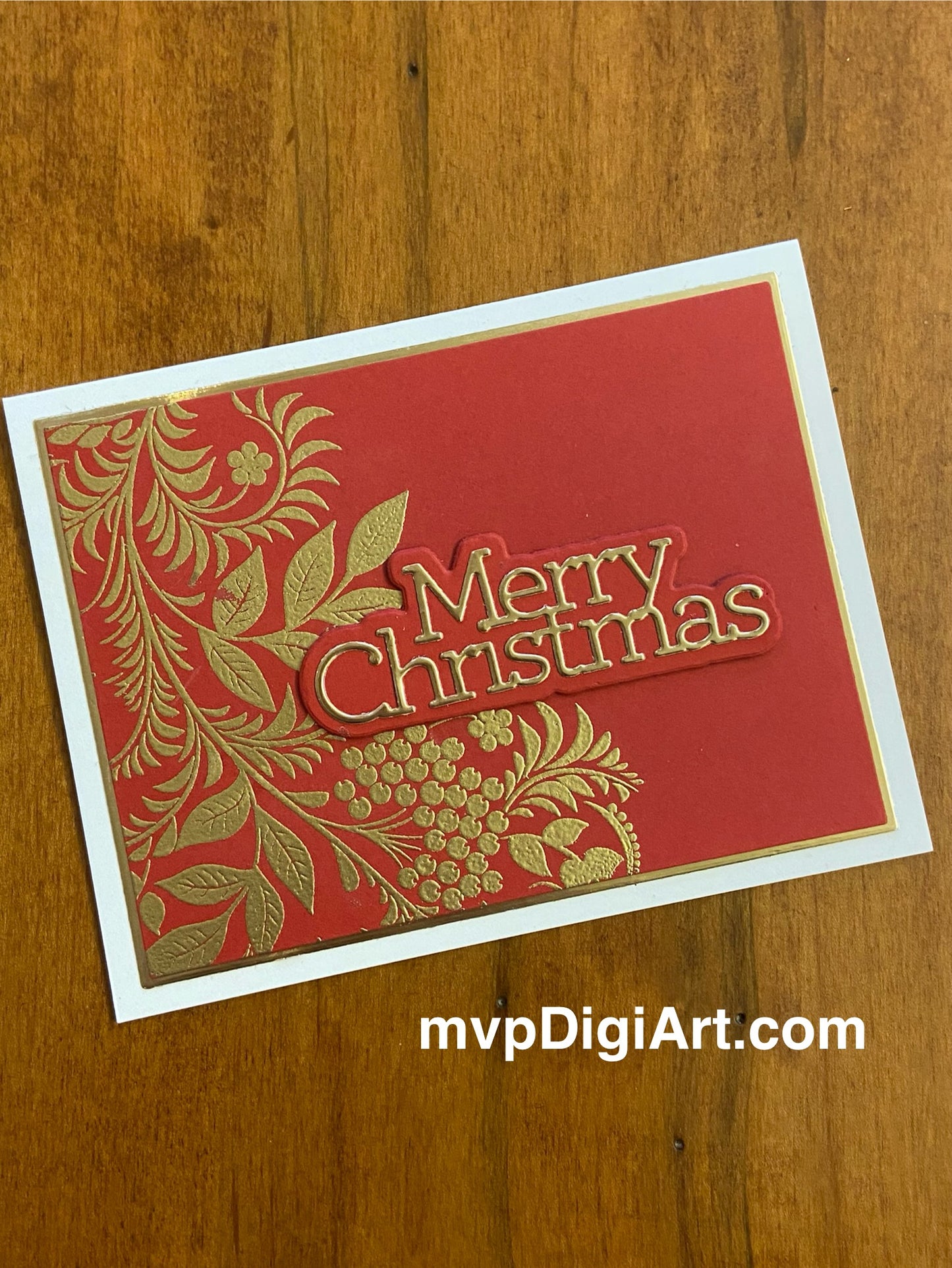 Handmade Christmas card with metallic embossed botanical foliage in gold and red with 'Merry Christmas' sentiment