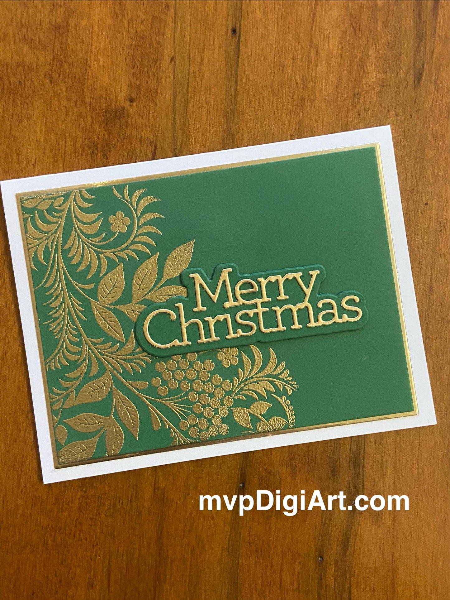 Handmade Christmas card with metallic embossed botanical foliage in green and gold with 'Merry Christmas' sentiment