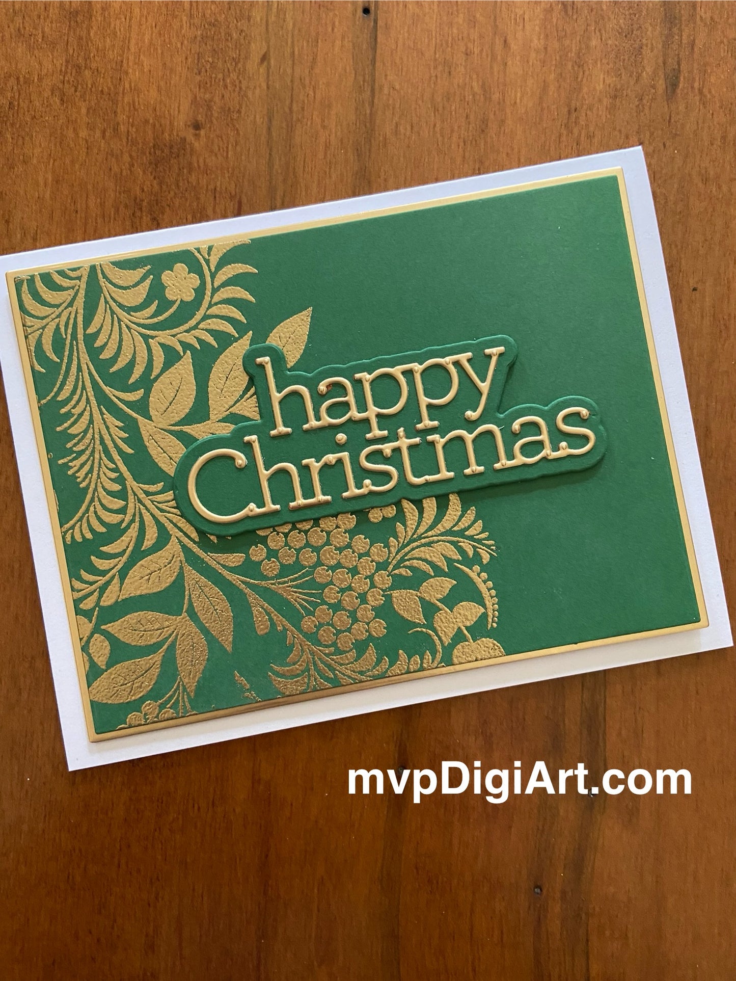 Handmade Christmas card with gold embossed foliage on green cardstock and die-cut gold Happy Christmas sentiment