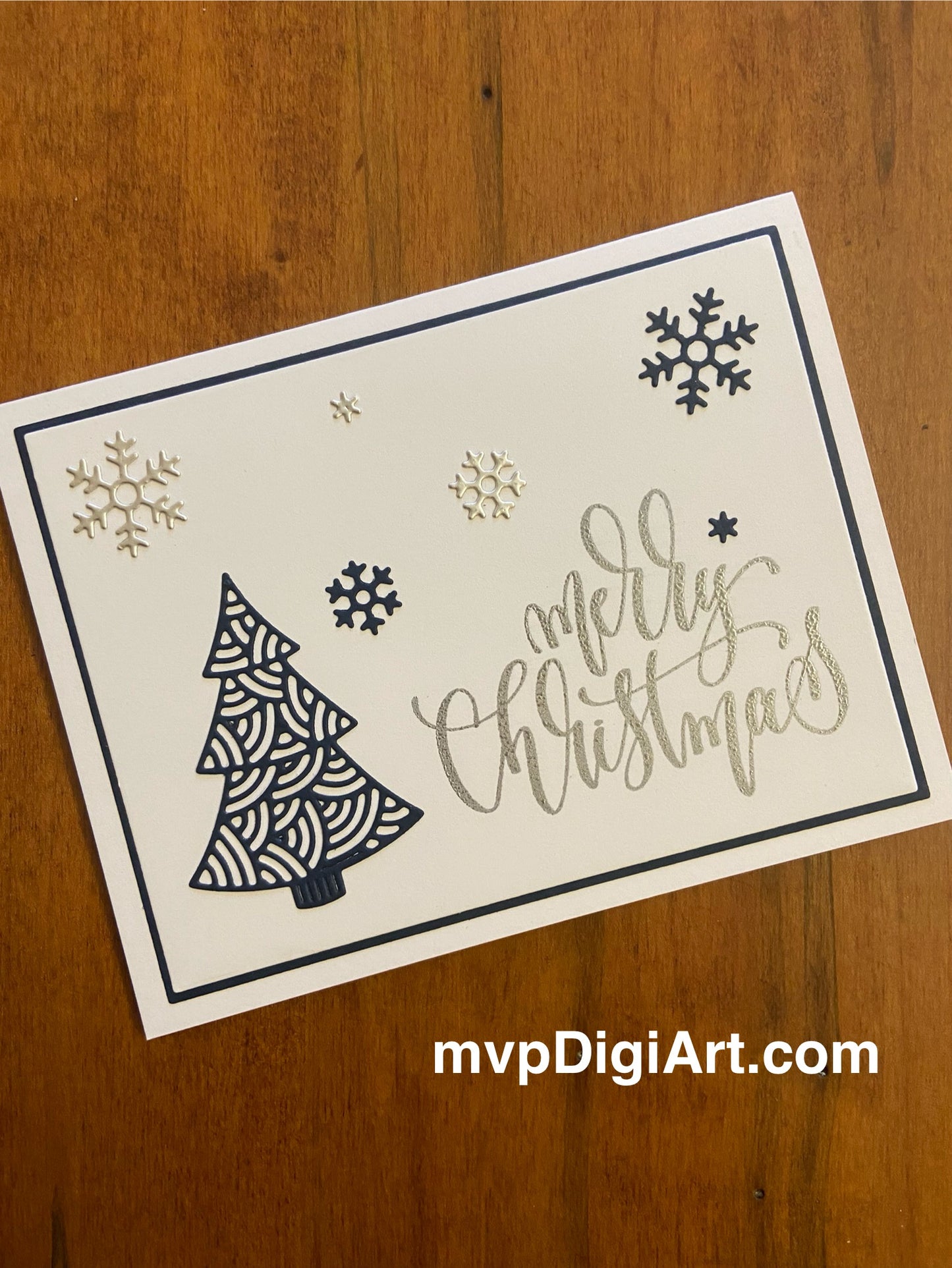 Handmade Christmas card with elegant navy blue filigree tree and silver snowflakes on white background