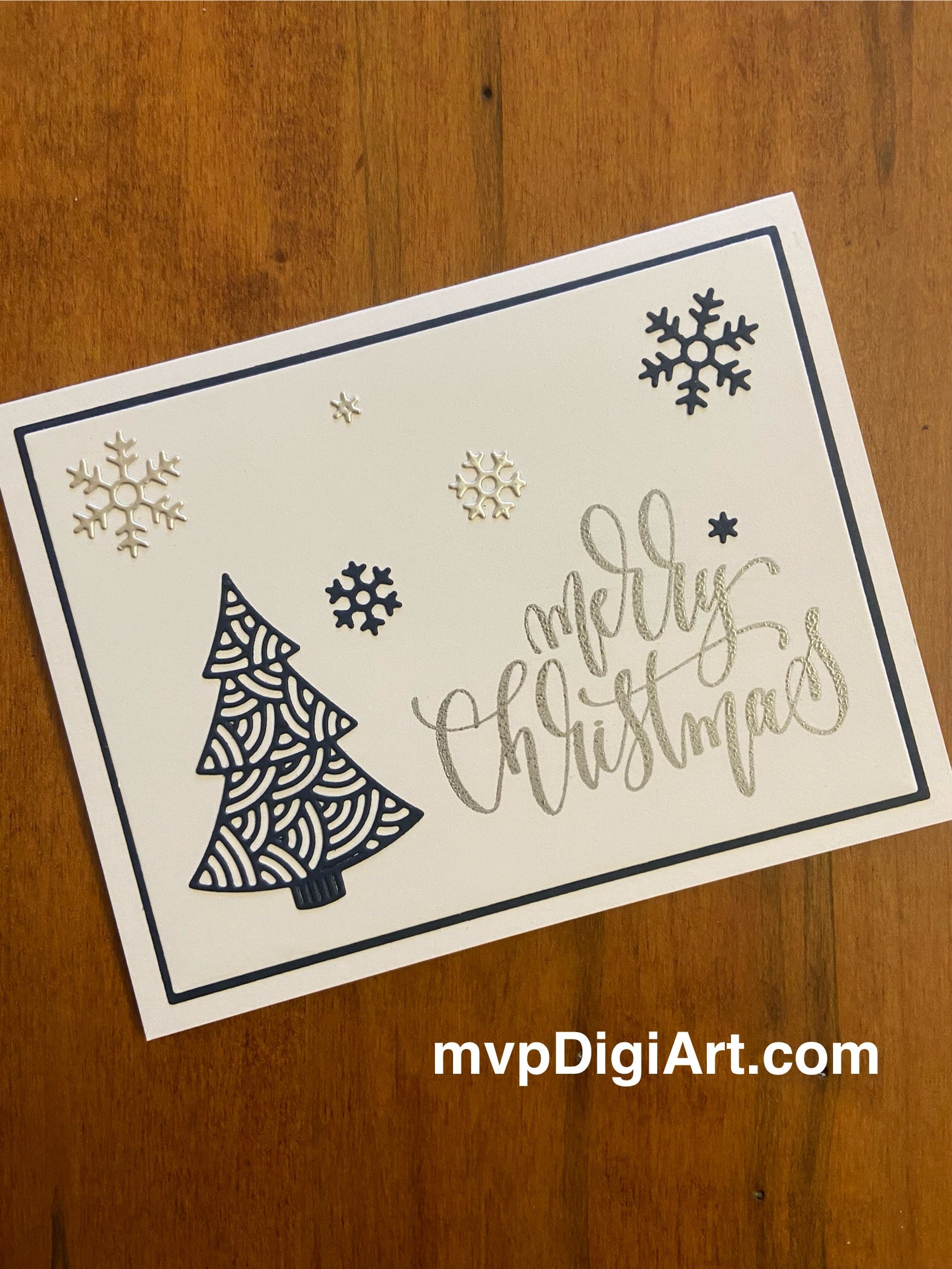 Handmade Christmas card with elegant navy blue filigree tree and silver snowflakes on white background
