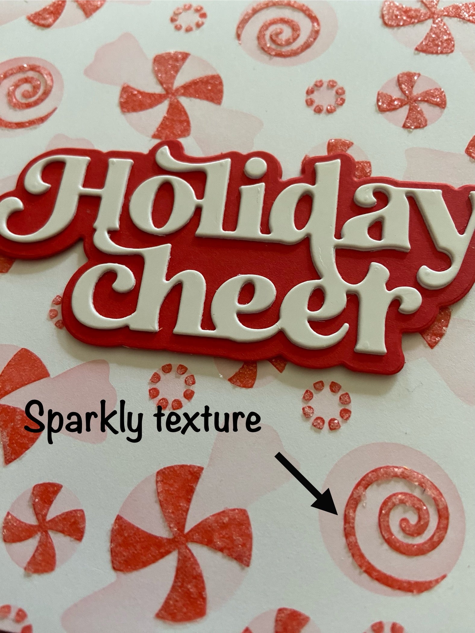 Close-up detail of handmade square Christmas card showing peppermint candy pattern, texture and dimension