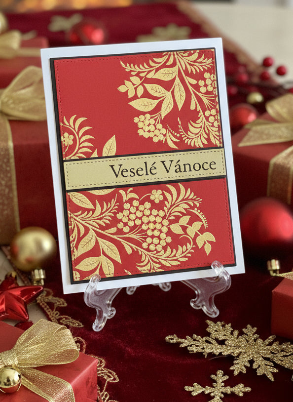 Czech Christmas card with embossed gold foliage and Veselé Vánoce greeting displayed standing with red and gold wrapped gifts
