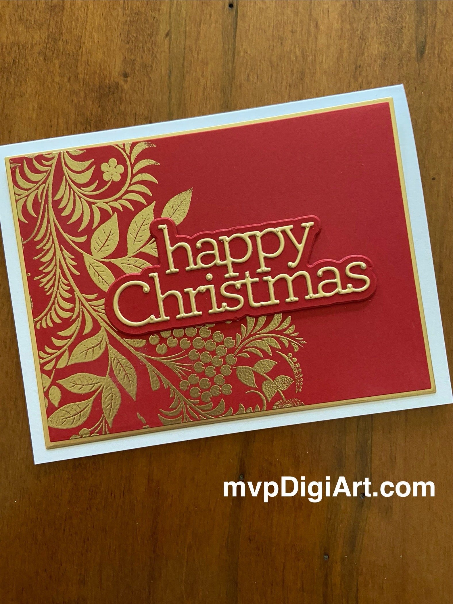 Handmade Christmas card with gold embossed foliage on red cardstock and die-cut gold Happy Christmas sentiment