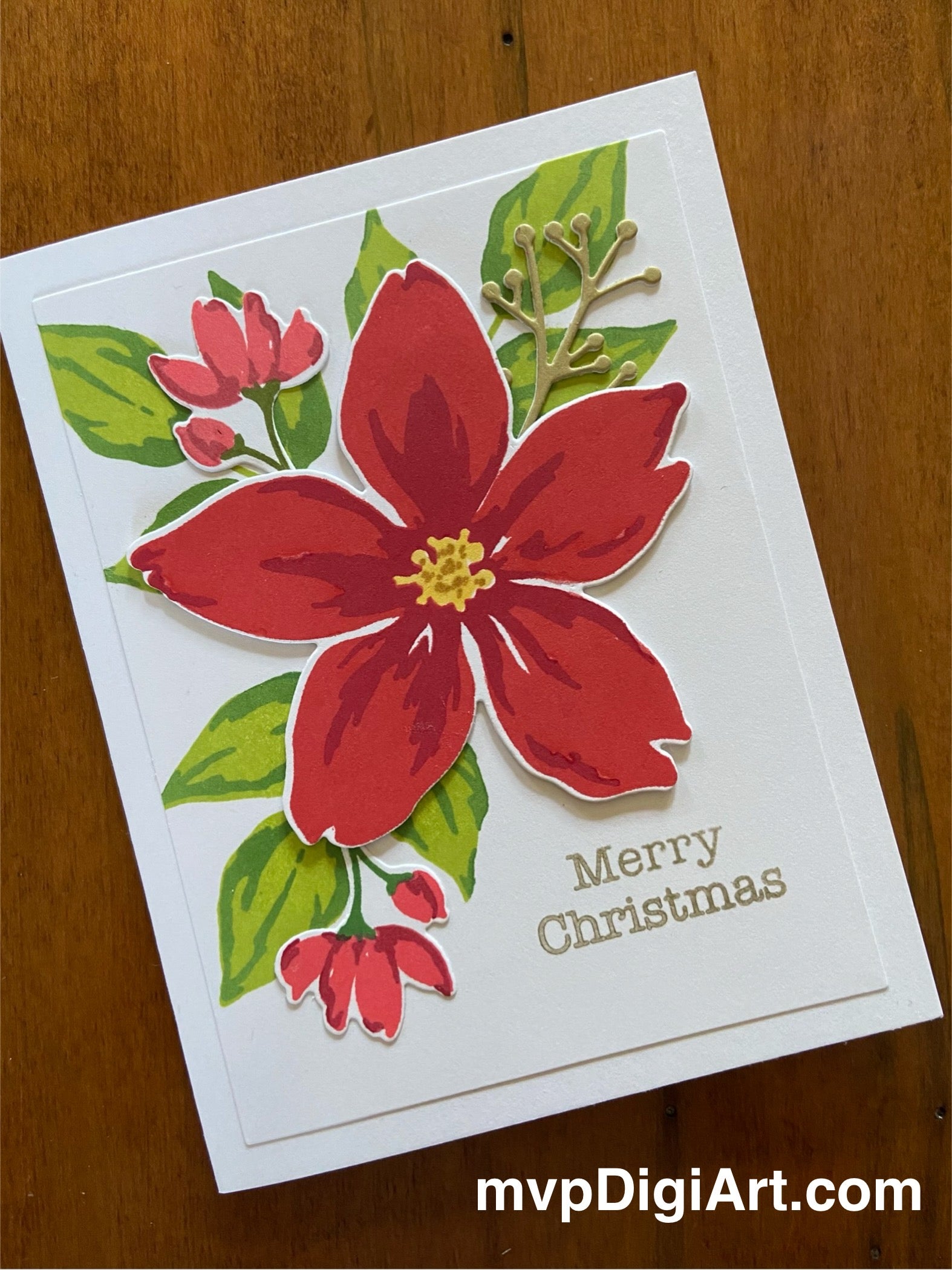 Handmade Christmas card with a white background featuring red poinsettia, greenery, and a gold 'Merry Christmas' sentiment.