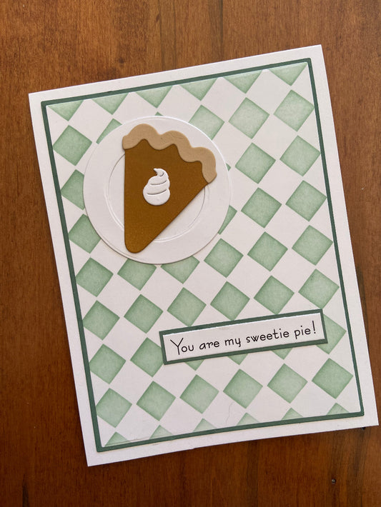 Handmade love card featuring a slice of pumpkin pie with whipped cream on a green harlequin stencilled background, with the sentiment "You Are My Sweetie Pie!"