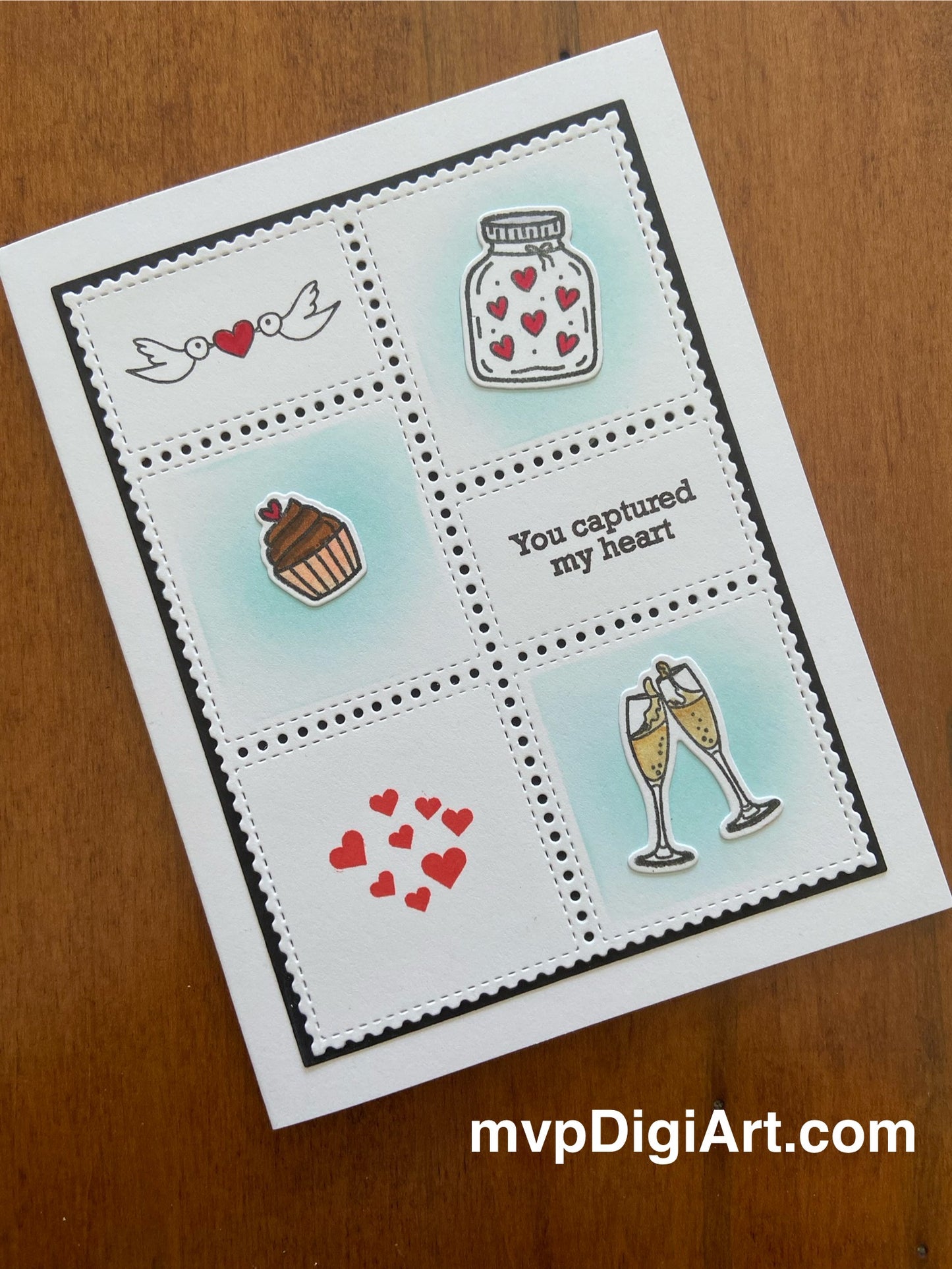 A handmade greeting card with a postage stamp style front panel featuring hand-stamped images including a heart and the phrase 'You captured my heart'. 