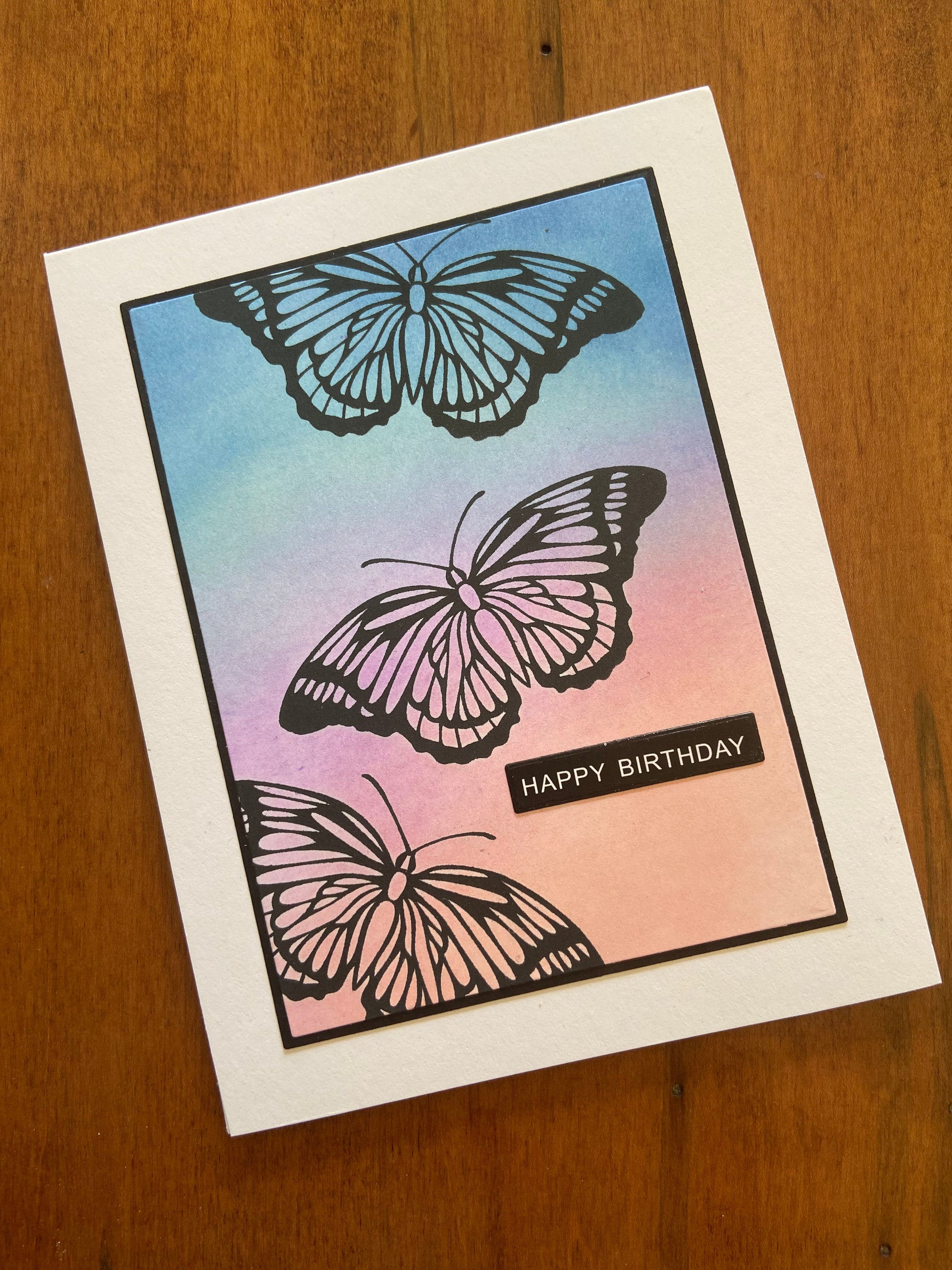 Card with butterfly designs and 'Happy Birthday' text on ink blended background in shades of pink to blue, part of the 4 pack set