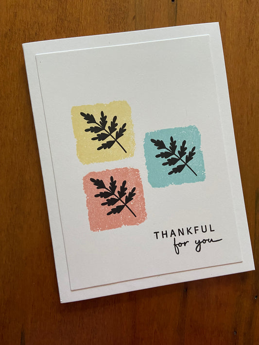 Handmade thankful for you card with three colour-blocked squares in yellow, pink, and turquoise, each stamped with black fern silhouettes