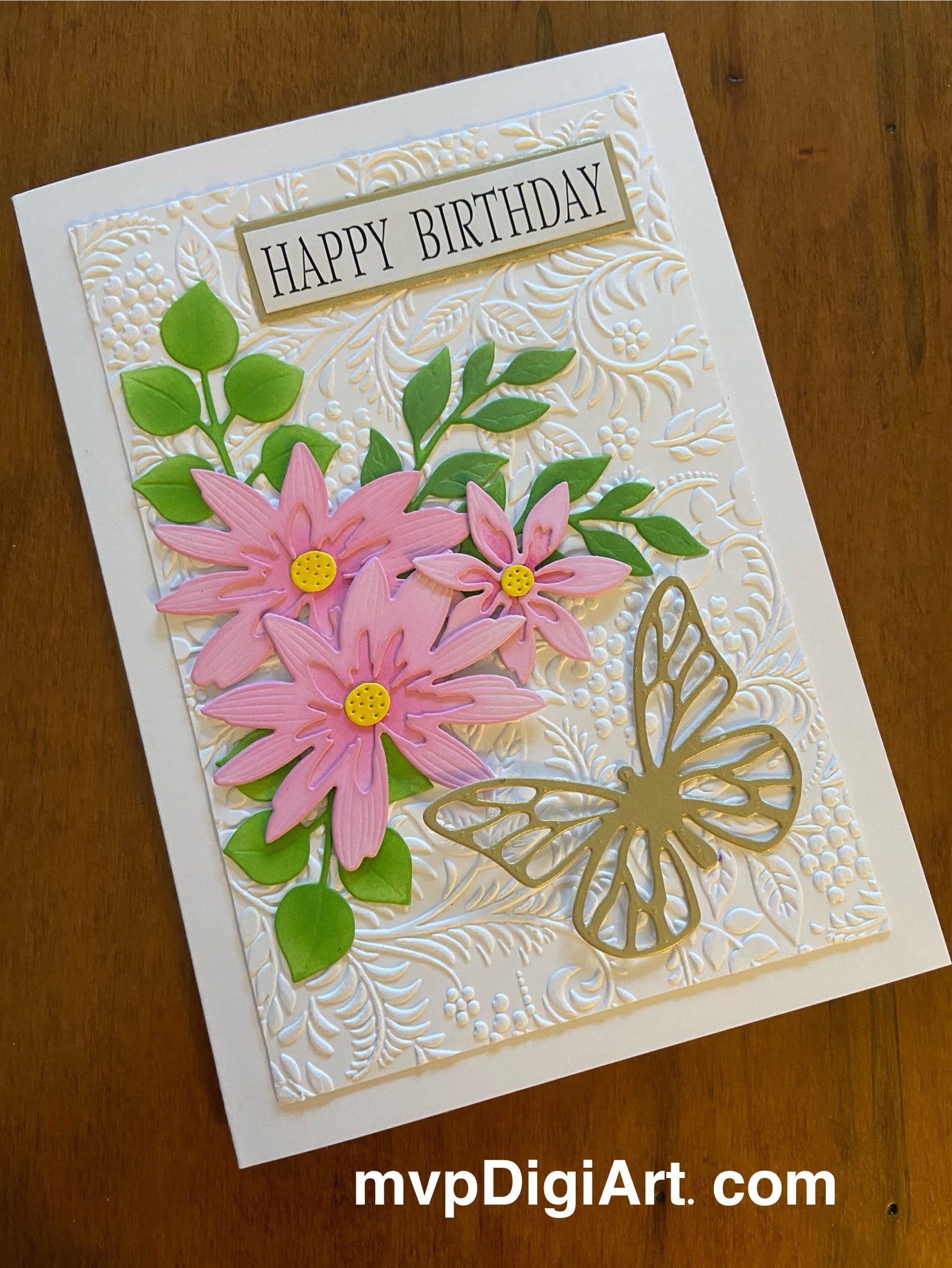 Trio of pink daisies; green foliage and a gold tone butterfly. All die cuts and lots of dimension. 