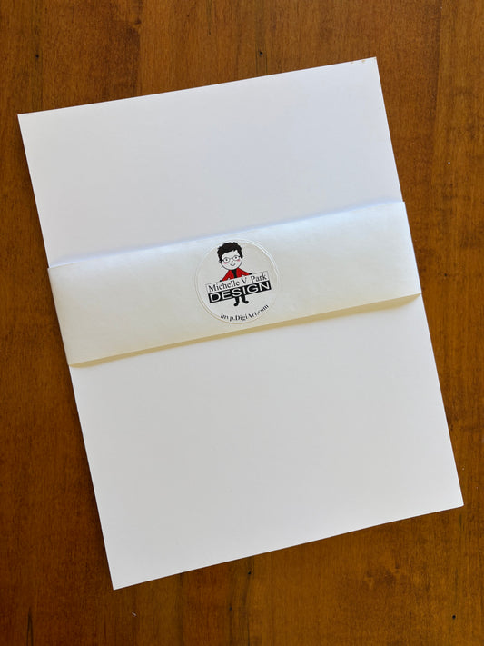 A stack of plain white cardstock, 8.5 x 11, wrapped in a Michelle V. Park Design branded belly band.