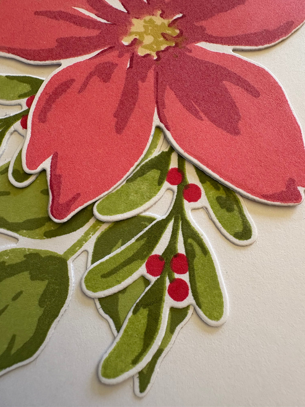 Close up of the white gift card holder tag with the red poinsettia and greenery