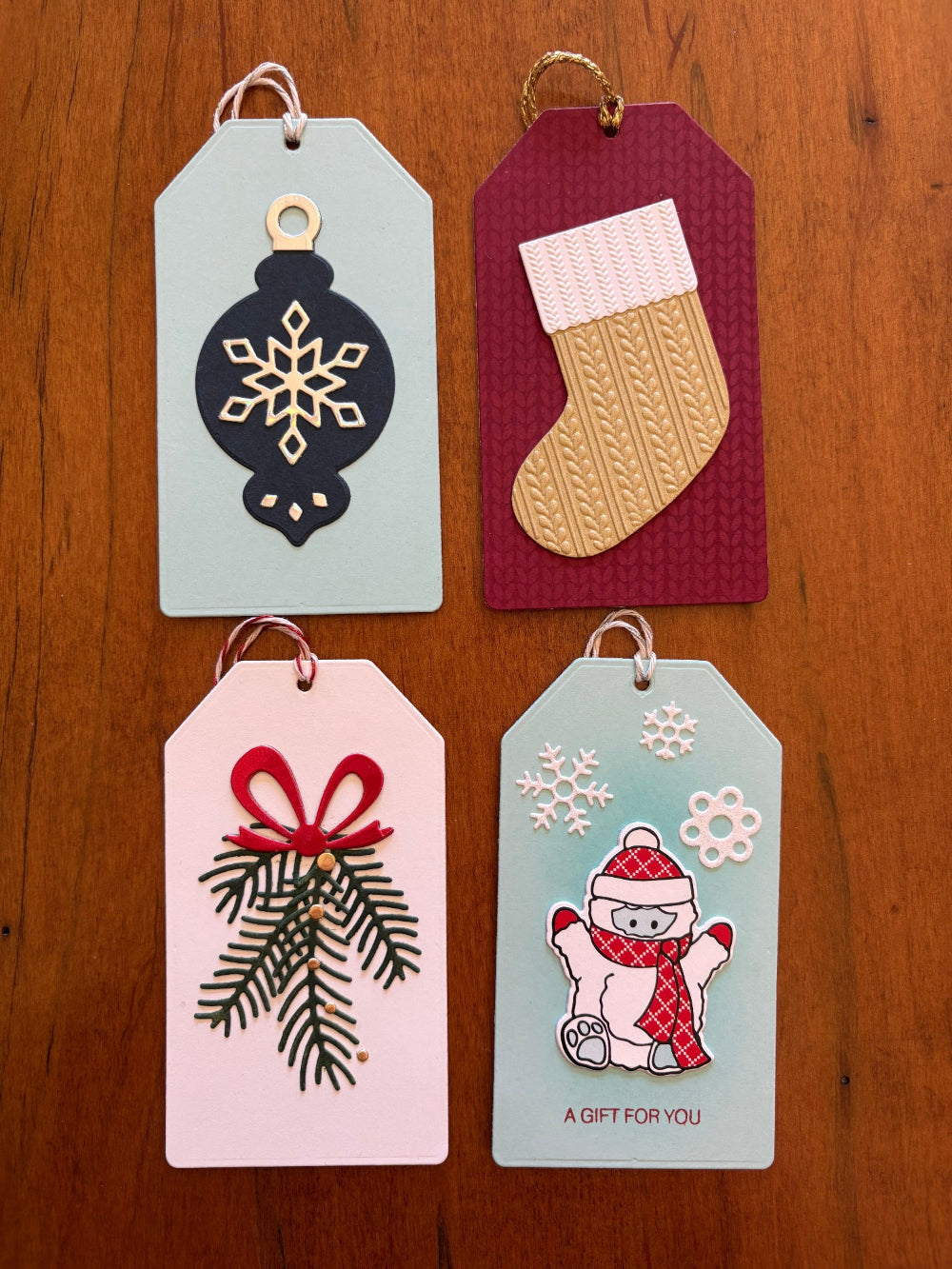 Christmas gift tags featuring blue ornament, pine sprigs, yeti and stocking - front view