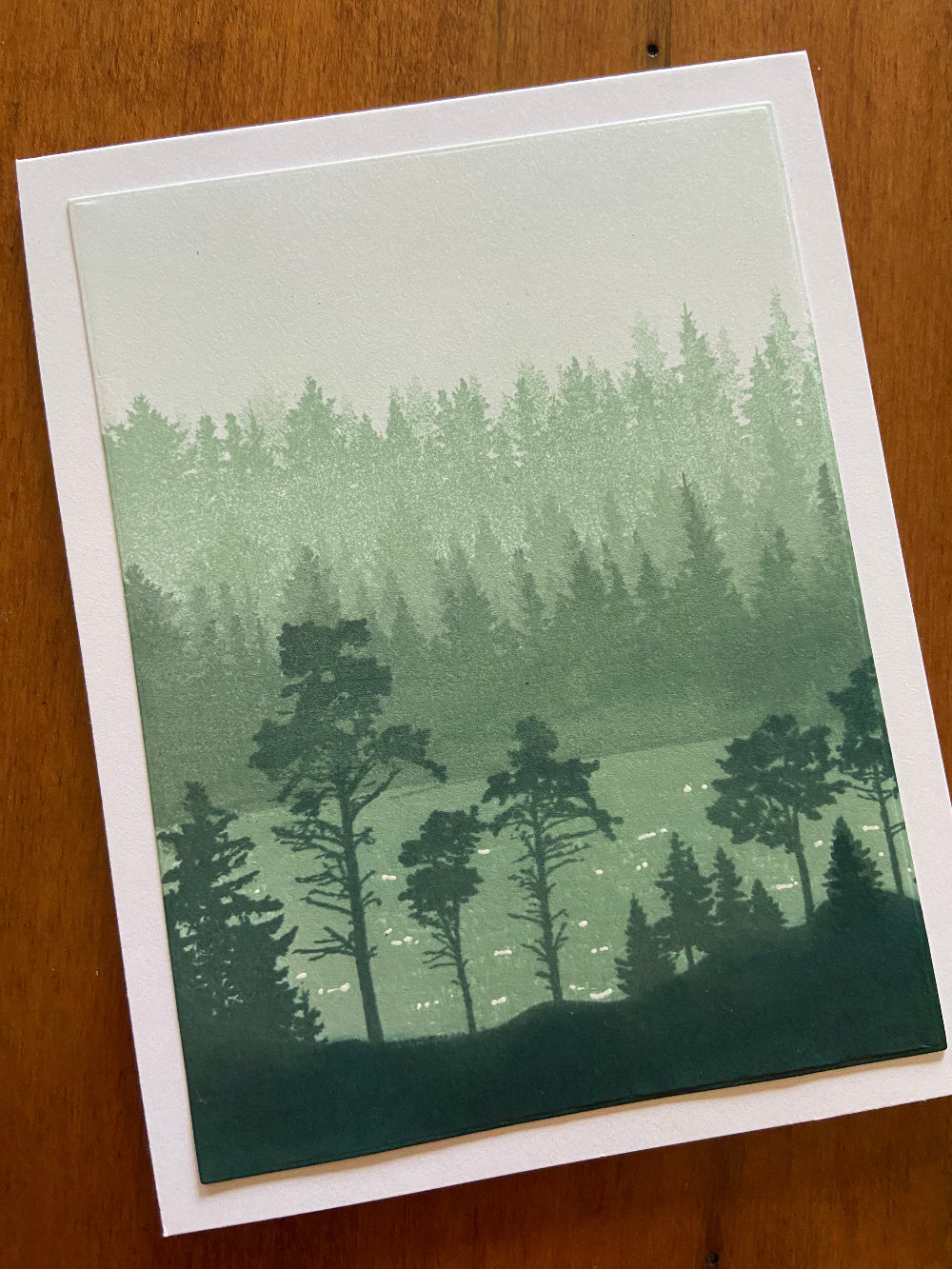 Handmade all occasion card with forest and lake scene hand-stamped in light, medium and dark spruce green tones