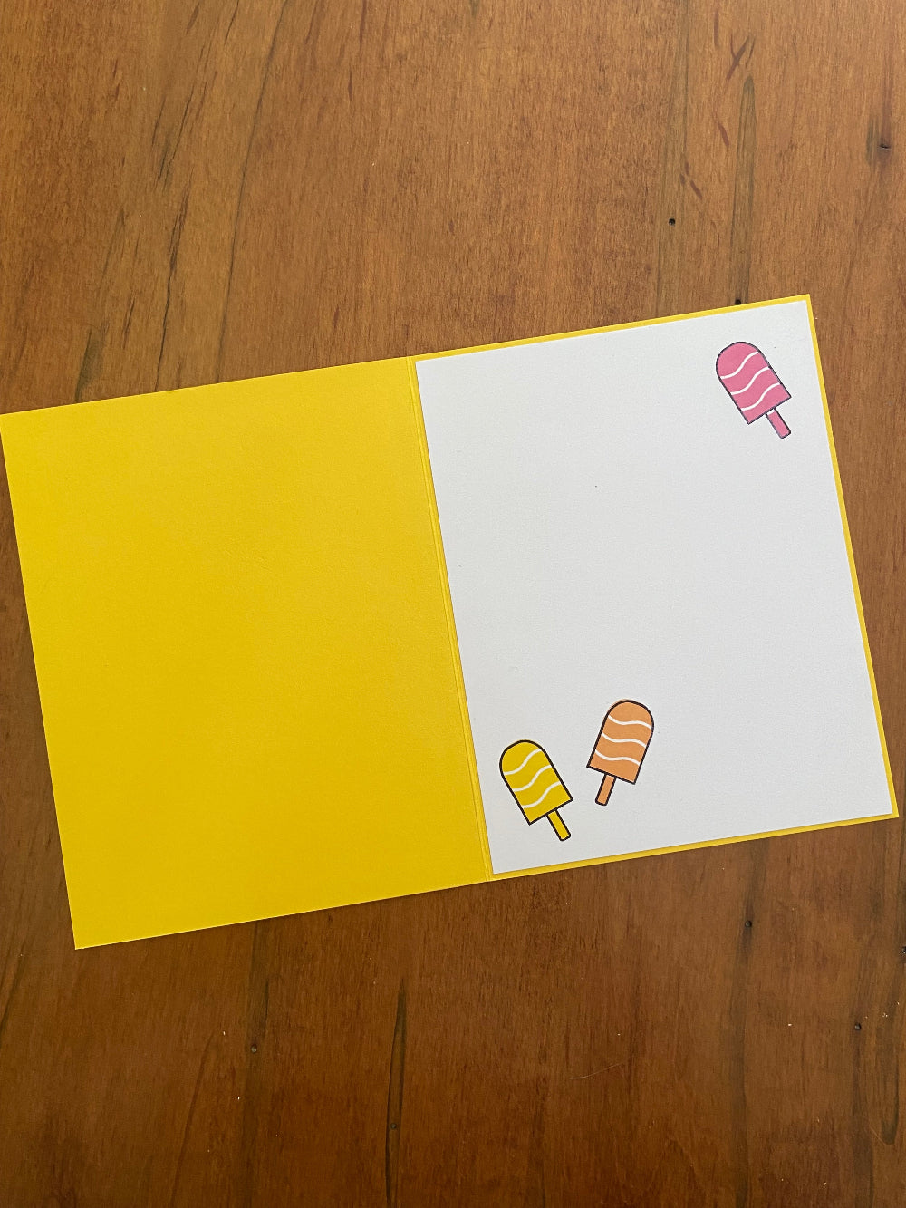 Inside of handmade birthday card showing a white panel for a personal message, with popsicle motif accents.