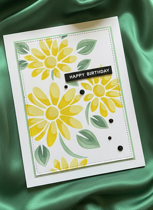 Birthday card with yellow flowers and green leaves on a green fabric background