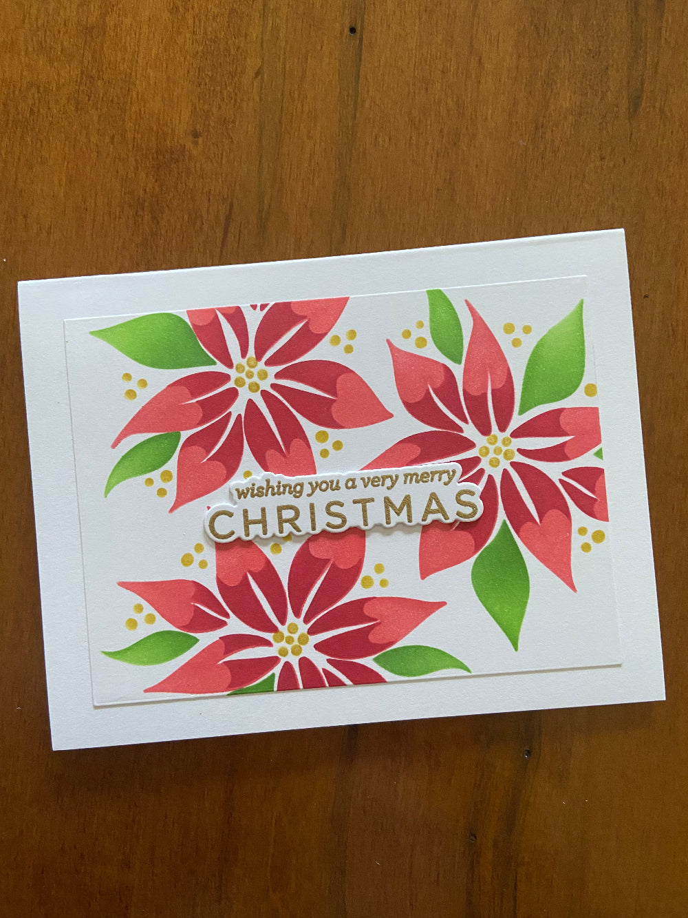 Christmas card with red poinsettias and 'wishing you a very merry Christmas' text in gold