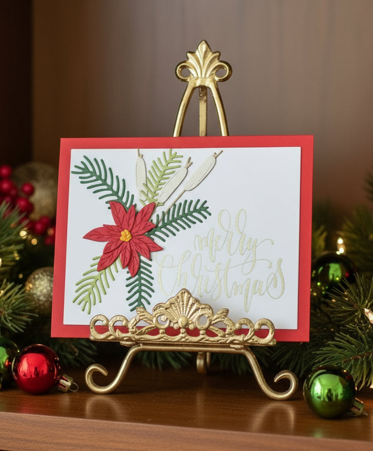 Handmade Christmas card with red poinsettia, spruce sprigs, and cattails displayed on Christmas-themed decorated shelf 