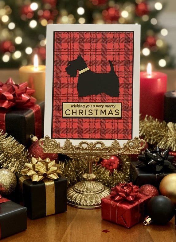 Christmas card with red plaid pattern and Scottish Terrier silhouette with 'Wishing you a very merry Christmas' text displayed on table with wrapped gifts