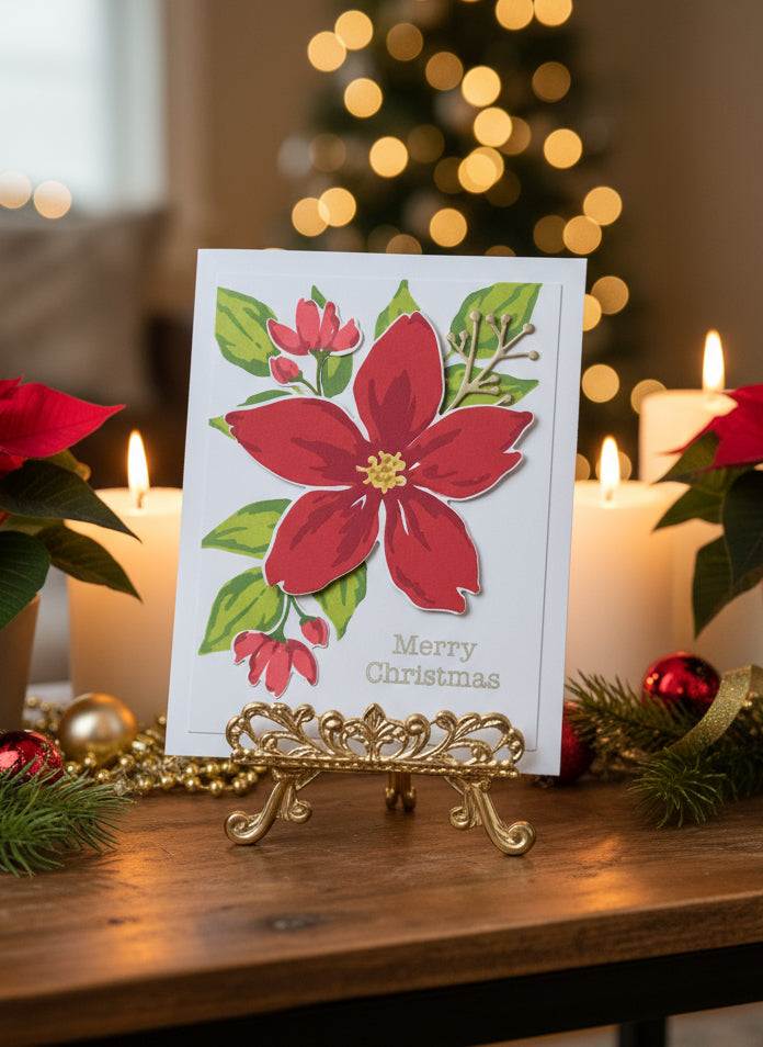 Christmas card with poinsettia design on a decorative stand, surrounded by candles and holiday decorations.