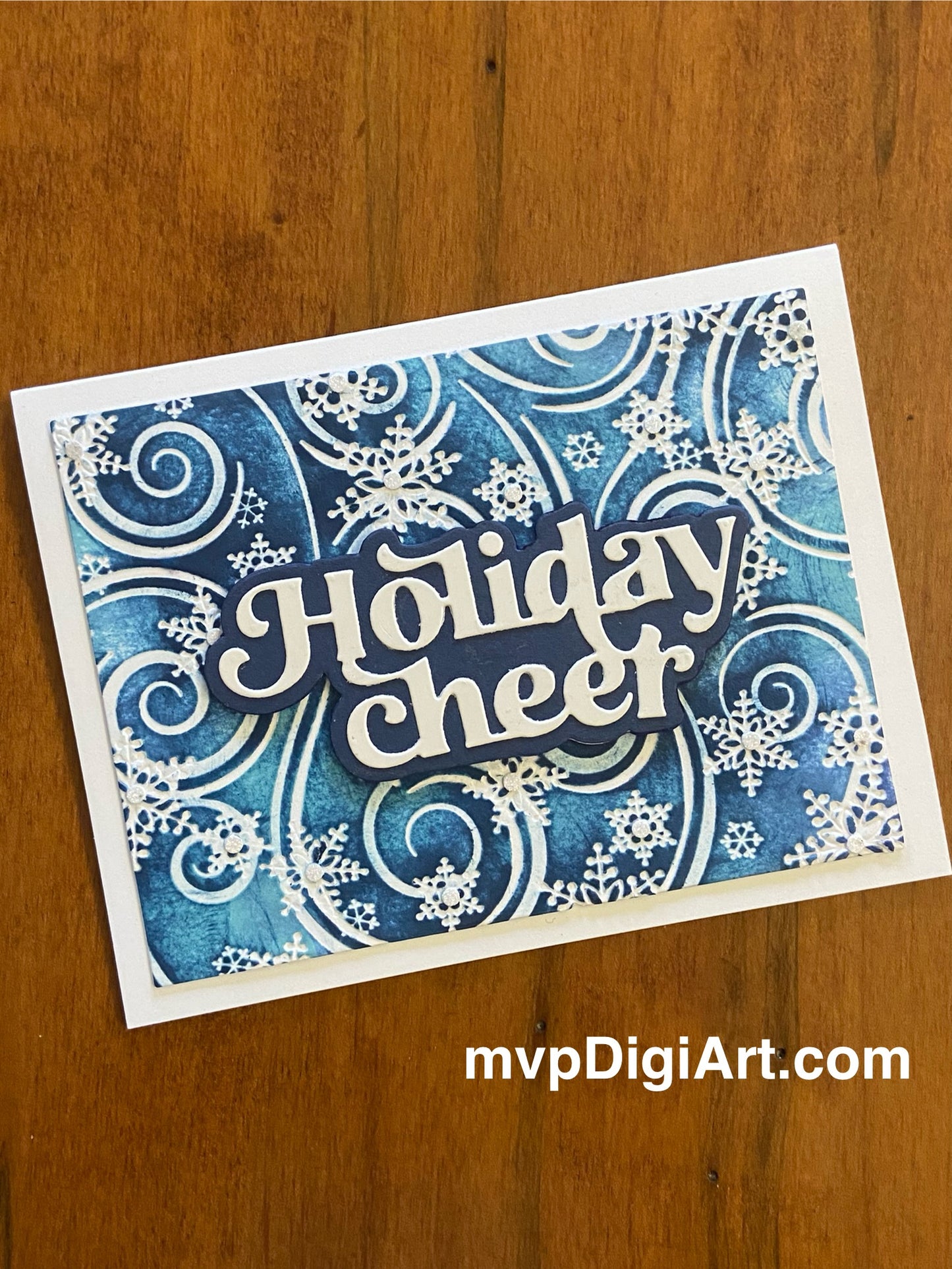 Handmade Christmas card with swirling blue and white snowflakes with glitter accents and die-cut Holiday Cheer sentiment