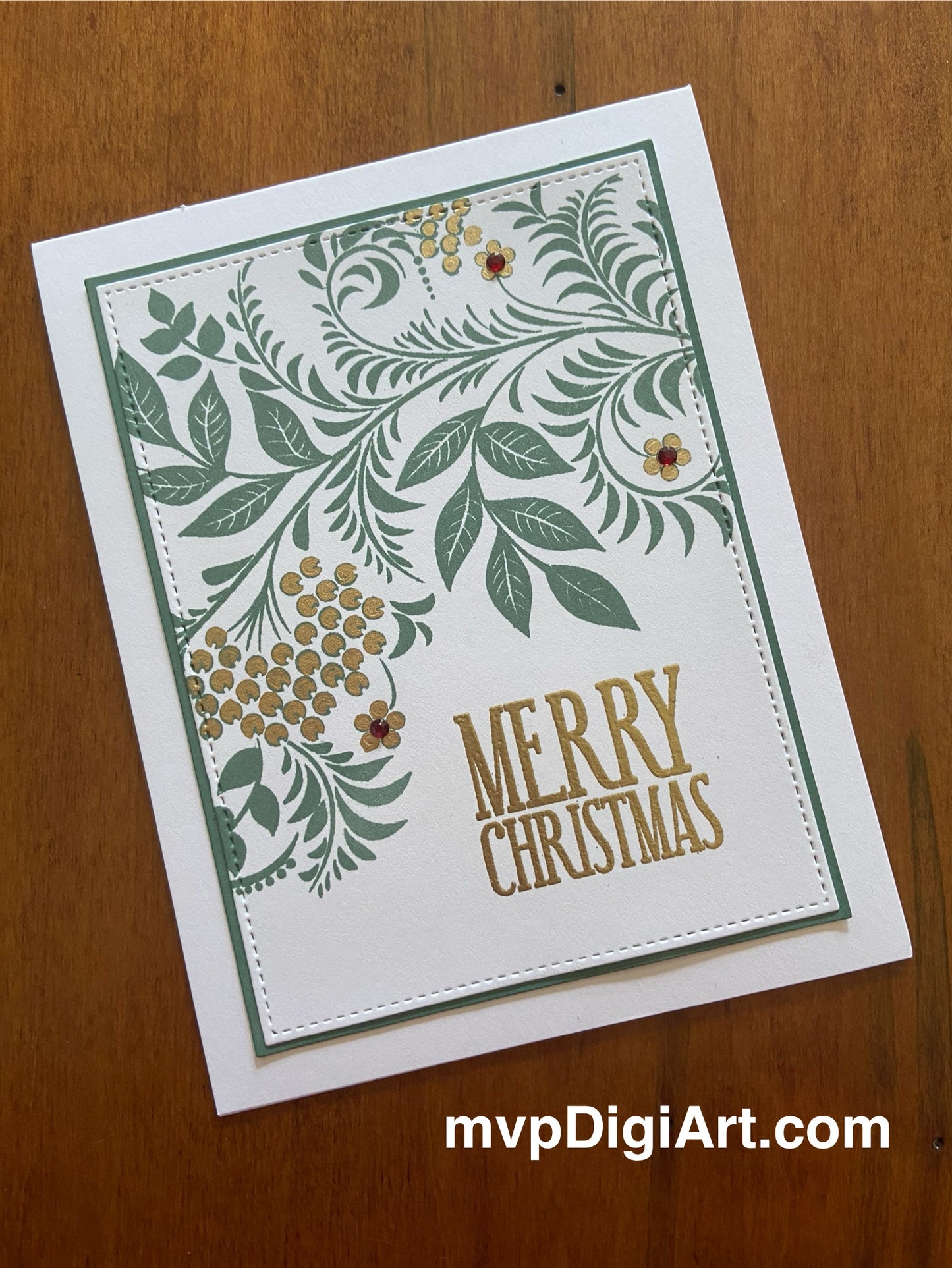 Handmade Christmas card with spruce and gold foliage design, gold embossing, and gem accents on white background